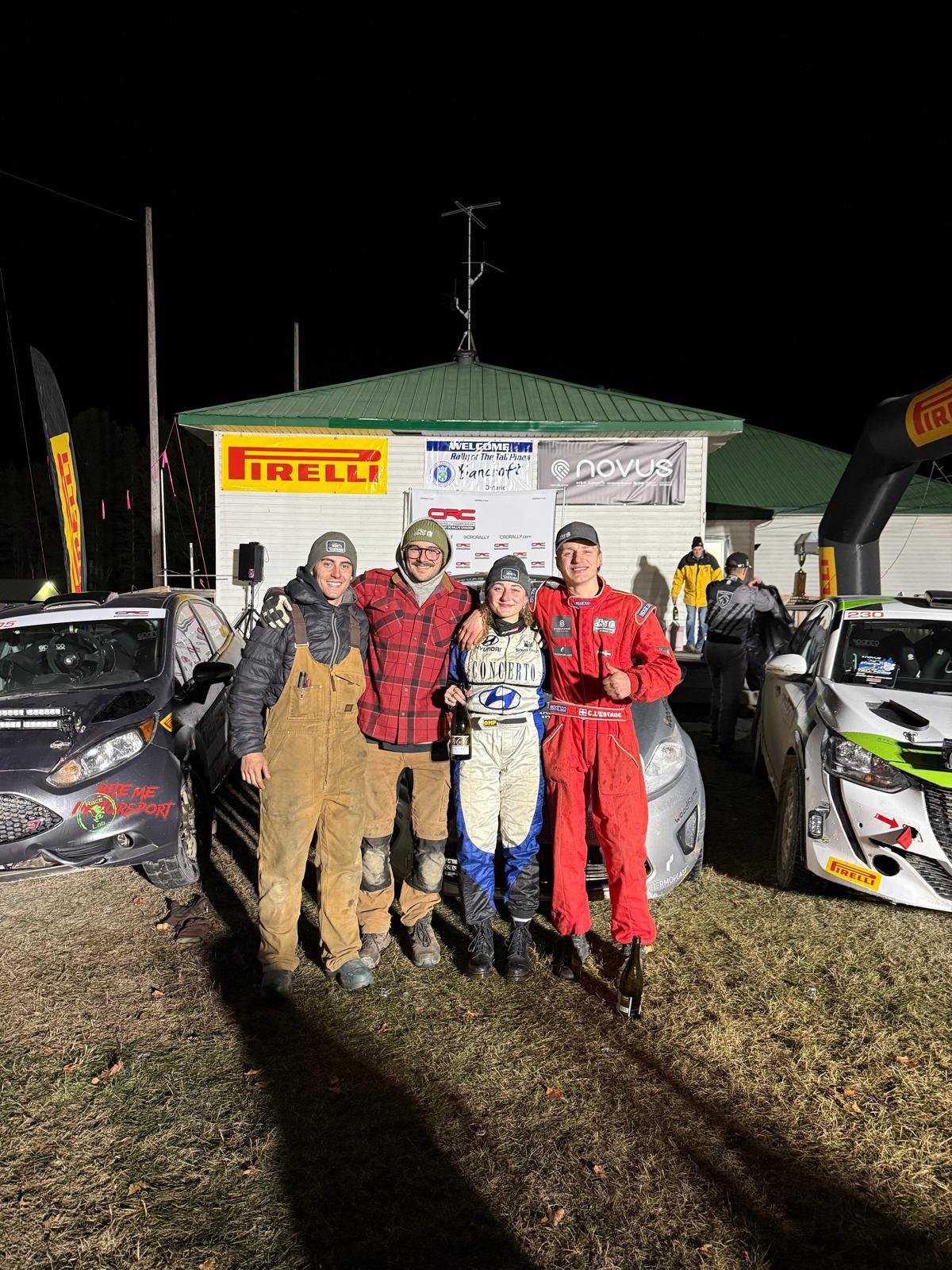 Charles et Juliette L'Estage avec leurs mécaniciens devant la voiture, de nuit, à l'arrivée du Rallye Tall Pines