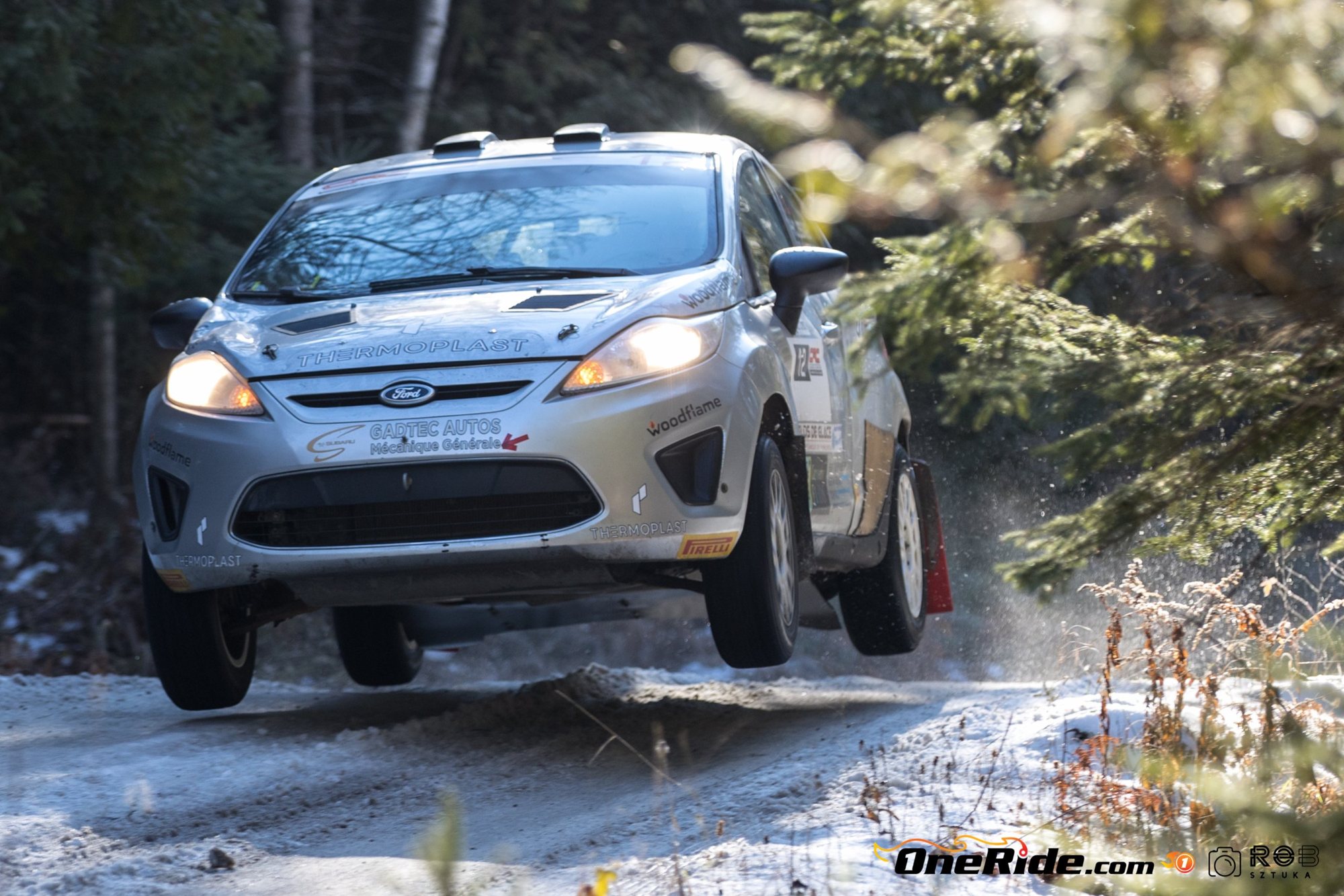 La Ford Fiesta en plein saut sur une route enneigée, phares allumés